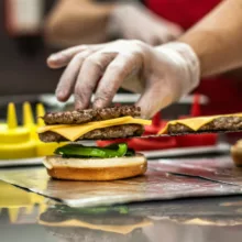 Mise en place d'un burger végétal avec des gants en latex